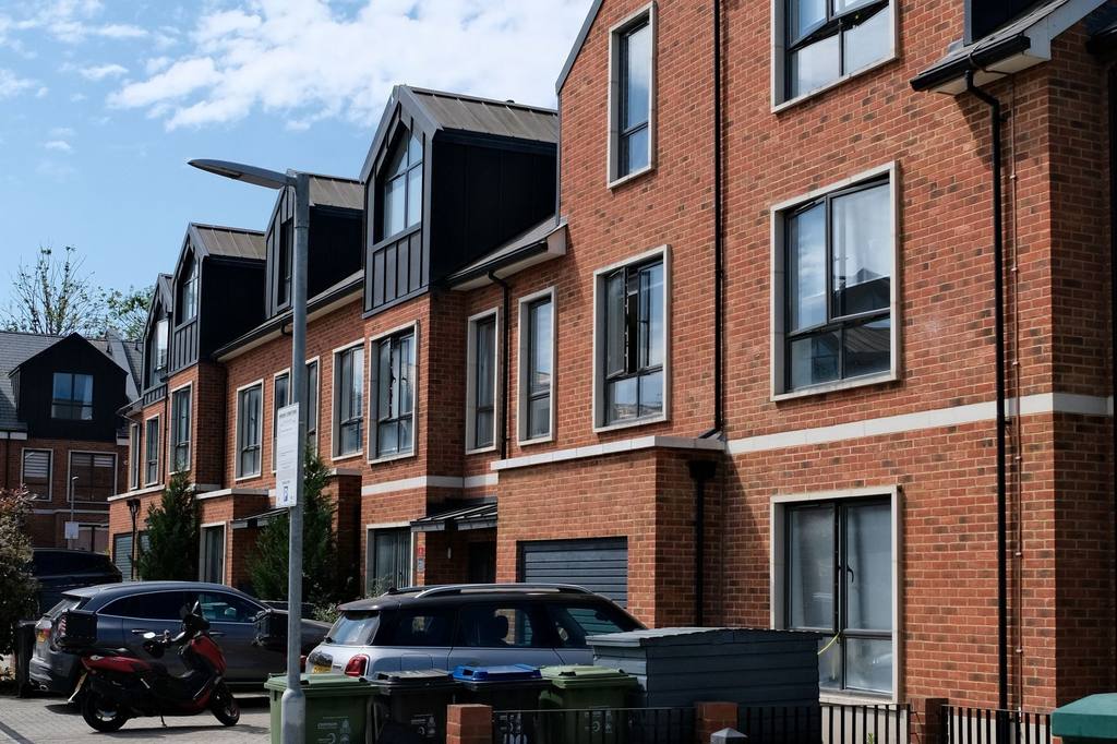 Modern brick town houses with dark cladding on a new residential street in London