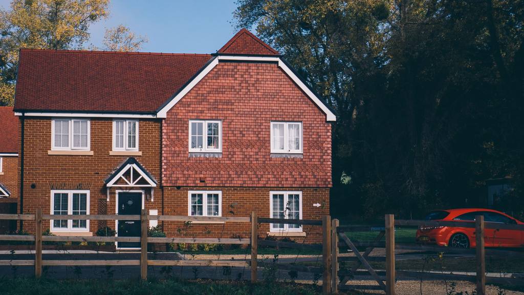 Newly built red-brick detached family house with a gabled porch in Surrey, England